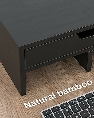 Black bamboo desk organizer with keyboard on wooden surface.