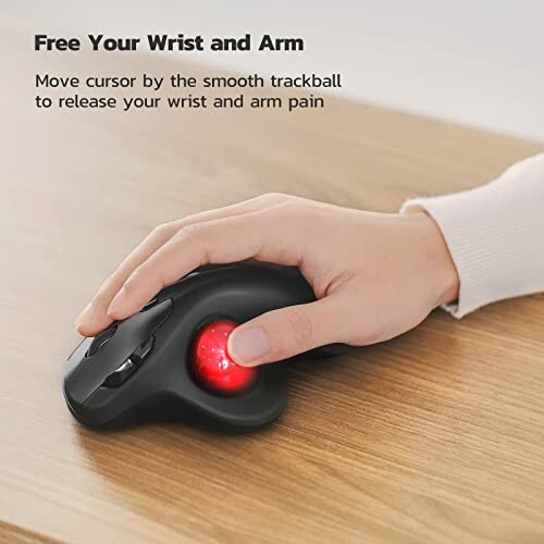 Hand using ergonomic trackball mouse on a wooden table.