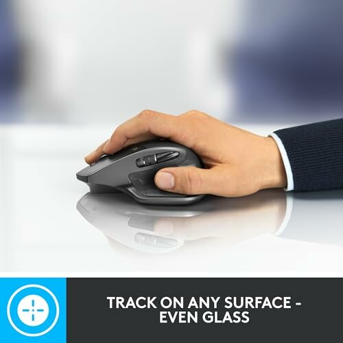 Hand using ergonomic wireless mouse on glass surface.