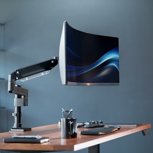 Curved monitor on adjustable arm at a minimalist desk setup.