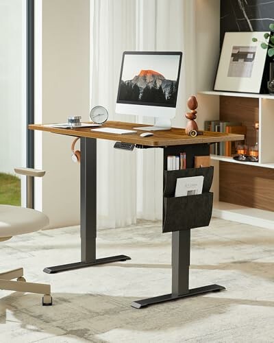 Modern standing desk with computer and accessories in a bright room.
