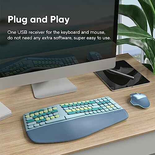 Wireless keyboard and mouse on a desk with a computer monitor.