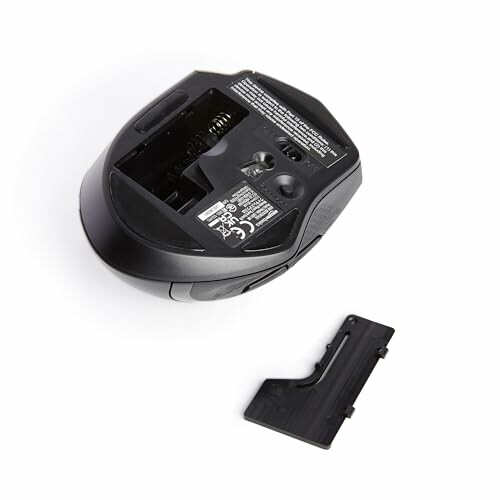 Wireless mouse with open battery compartment and cover removed.
