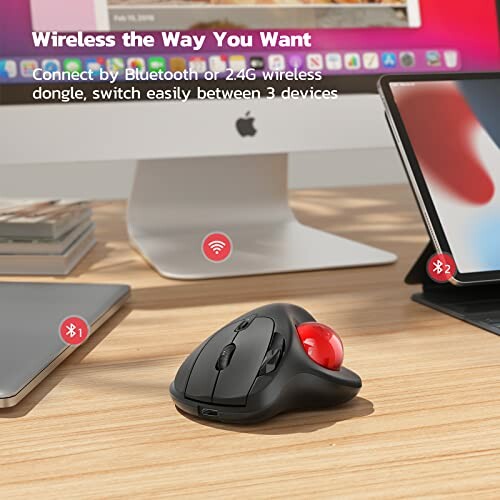 Wireless trackball mouse in front of computer and tablet.